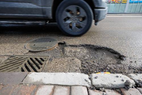 MIKE DEAL / FREE PRESS
                                Vehicles dodge potholes on Osborne Street close to Wardlaw Avenue Monday morning.