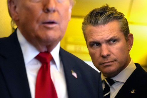 Defense Secretary Pete Hegseth listens as President Donald Trump speaks to reporters while traveling aboard Air Force One en route from Dover Air Force Base, Del., to Miami, Saturday, March 7, 2026. (AP Photo/Mark Schiefelbein)