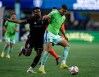 Seattle Sounders forward Osaze De Rosario, right, battles Colorado Rapids midfielder Hamzat Ojediran for the ball during an MLS soccer match, Sunday, Feb. 22, 2026, in Seattle. (AP Photo/Stephen Brashear)