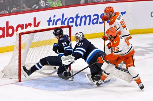 Anaheim Ducks' Tim Washe (42) scores on Winnipeg Jets goaltender Connor Hellebuyck (37) as Haydn Fleury (24) defends during the second period of their NHL hockey game in Winnipeg, Tuesday March 10, 2026. THE CANADIAN PRESS/Fred Greenslade