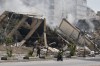 Men pass a building destroyed in an Israeli airstrike in Dahiyeh, Beirut's southern suburbs, Lebanon, Thursday, March 12, 2026. (AP Photo/Bilal Hussein)