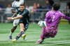 Seattle Sounders' Paul Arriola (17) is stopped by Vancouver Whitecaps goalkeeper Yohei Takaoka (1) during the first half of a CONCACAF Champions Cup soccer match, in Vancouver, on Thursday, March 12, 2026. THE CANADIAN PRESS/Darryl Dyck