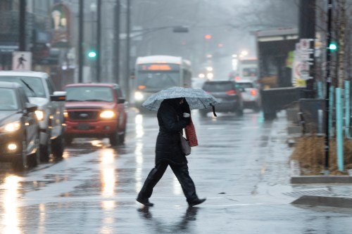 A pedestrian shields themselves from rain and wind during a rainfall warning in Halifax on Thursday, Jan. 26, 2023. THE CANADIAN PRESS/Darren Calabrese