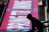 A fan talks to a player on the field prior to a spring training baseball game between the Los Angeles Angels and the Kansas City Royals Monday, March 2, 2026, in Tempe, Ariz. (AP Photo/Ross D. Franklin)