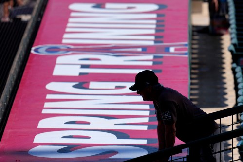 A fan talks to a player on the field prior to a spring training baseball game between the Los Angeles Angels and the Kansas City Royals Monday, March 2, 2026, in Tempe, Ariz. (AP Photo/Ross D. Franklin)