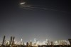 Missiles launched from Iran streak across the sky over central Israel, Wednesday, March 18, 2026. (AP Photo/Ohad Zwigenberg)