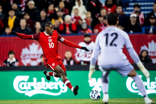 Canada's Jonathan David (10) shoots on Australian goalkeeper Paul Izzo (12) during an international men's soccer friendly in Montreal on Friday, Oct. 10, 2025. THE CANADIAN PRESS/Christopher Katsarov