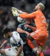 Seattle Sounders goalkeeper Stefan Frei, right, collides with teammate Jackson Ragen, centre, as he vies for the ball against Vancouver Whitecaps' Brian White, left, during the second half of a CONCACAF Champions Cup soccer match, in Vancouver, on Thursday, March 12, 2026. THE CANADIAN PRESS/Darryl Dyck