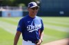 Los Angeles Dodgers manager Dave Roberts smiles as he walks to the team dugout prior to a spring training baseball game against the Milwaukee Brewers, Monday, March 16, 2026, in Phoenix. (AP Photo/Ross D. Franklin)