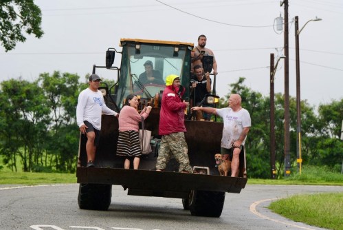 People are evacuated from Haleiwa, Hawaii, on a bulldozer Friday, March 20, 2026. (Craig Fujii/Hawaii Civil Beat via AP)