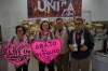 CODEPINK activists hold signs in front of boxes of aid they brought as part of the 