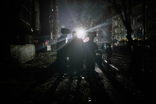 Ultra-Orthodox Jewish men watch as Israeli security forces and rescue teams operate at the site hit by an Iranian missile in Arad, southern Israel, Sunday, March 22, 2026. (AP Photo/Ohad Zwigenberg)