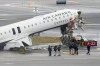 Officials with the National Transportation Safety Board investigate the site, Monday, March 23, 2026, where an Air Canada jet came to rest after colliding with a Port Authority firetruck at LaGuardia Airport, shortly after landing Sunday night in New York. (AP Photo/Seth Wenig)