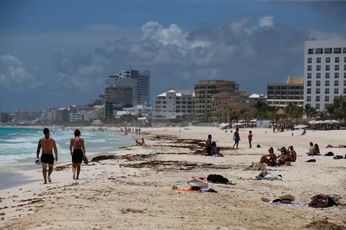 Tourists enjoy the beach in Cancun, Quintana Roo State, Mexico, Wednesday, Aug. 18, 2021. (AP Photo/Marco Ugarte)