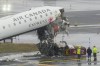 Officials investigate the site, Monday, March 23, 2026, where an Air Canada jet came to rest after colliding with a Port Authority fire truck at LaGuardia Airport, shortly after landing Sunday night in New York. (AP Photo/Seth Wenig)