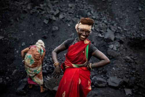 FILE- A laborer smiles as she takes a break from loading coal into a truck in Dhanbad, an eastern Indian city in Jharkhand state, on Sept. 24, 2021. (AP Photo/Altaf Qadri, File)
