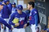 Los Angeles Dodgers starting pitcher Roki Sasaki (11) is greeted by designated hitter Shohei Ohtani, right, after being taken off the mound during the first inning of a spring training baseball game against the Los Angeles Angels, Monday, March 23, 2026, in Los Angeles. (AP Photo/Ryan Sun)