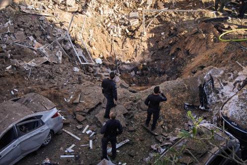 Israeli security forces and rescue teams inspect the site of an Iranian missile strike in Tel Aviv, Israel, Tuesday, March 24, 2026. (AP Photo/Oded Balilty)
