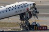 Suitcases are seen in the wreckage of an Air Canada Express jet, Tuesday, March 24, 2026, just off the runway where it collided with a Port Authority fire truck Sunday night at LaGuardia Airport in New York. (AP Photo/Yuki Iwamura)
