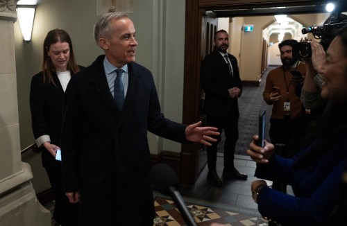 Prime Minister Mark Carney speaks briefly with reporters as he arrives on Parliament Hill in Ottawa on Tuesday, March 24, 2026. THE CANADIAN PRESS/Adrian Wyld