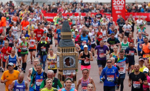 FILE - Lukas Bates wearing a costume of the Queen Elizabeth Tower (known as Big Ben) runs with the crowd towards the finish line of the 39th London Marathon in London, Sunday, April 28, 2019. (AP Photo/Alastair Grant, File)