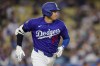 Los Angeles Dodgers designated hitter Shohei Ohtani runs after hitting a double during the third inning of a spring training baseball game against the Los Angeles Angels, Monday, March 23, 2026, in Los Angeles. (AP Photo/Ryan Sun)