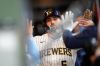 Milwaukee Brewers' Garrett Mitchell high-fives teammates after scoring on a single hit by Joey Ortiz (3) during the seventh inning of a baseball game against the Chicago White Sox, Saturday, March 28, 2026, in Milwaukee. (AP Photo/Kayla Wolf)