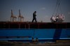 A worker walks on the deck of a feeder vessel as he works to offload cargo of rice into trucks at Umm Qasr Port, a deep-water port, in the city of Umm Qasr, Iraq, Friday, March 27, 2026. (AP Photo/Leo Correa)