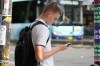 A youth is pictured using his phone as he waits to cross the street in Sydney, Monday, Dec. 8, 2025. (AP Photo/Rick Rycroft)
