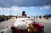 A quinceanera rides in a vintage car during her birthday celebration in Havana, Cuba, Saturday, March 28, 2026. (AP Photo/Ramon Espinosa)