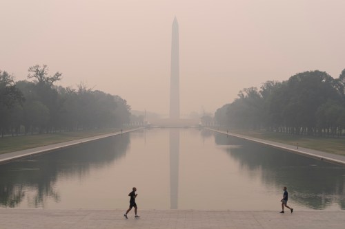 With the Washington Monument in the background and with a thick layer of smoke, people run at the National Mall, June 8, 2023, in Washington. (AP Photo/Jose Luis Magana, File)