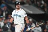 Seattle Mariners' Cal Raleigh walks back to the dugout after striking out with runners on base to end the fifth inning of an opening-day baseball game against the Cleveland Guardians, Thursday, March 26, 2026, in Seattle. (AP Photo/Lindsey Wasson)