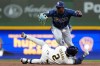 Tampa Bay Rays' Cedric Mullins, top, drops the ball as he attempts to tag Milwaukee Brewers' Brice Turang (2) out at second base during the fifth inning of a baseball game Tuesday, March 31, 2026, in Milwaukee. (AP Photo/Aaron Gash)