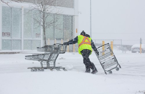 A worker wrangles shopping carts amid heavy snowfall in St. John's, Wednesday, Dec. 3, 2025. THE CANADIAN PRESS/Paul Daly