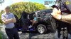 In this image from police body camera video released by the Martin County, Fla., Sheriff's Office, golfer Tiger Woods checks his cellphone as he sits in an unmarked police vehicle following a car crash in Jupiter Island, Fla., Friday, March 27, 2026. (Martin County Sheriff's Office via AP)