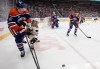Chicago Blackhawks forward Connor Bedard (98) and Oilers defenceman Connor Murphy (5) battle for the puck during an NHL game in Edmonton on April 2, 2026. THE CANADIAN PRESS/Jason Franson