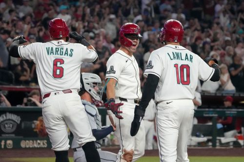 Arizona Diamondbacks' Corbin Carroll, middle, celebrates his three-run home run against the Detroit Tigers with Ildemaro Vargas (6) and Jordan Lawlar (10) during the second inning of an opening-day baseball game Monday, March 30, 2026, in Phoenix. (AP Photo/Darryl Webb)wld