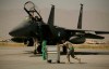 FILE - A U.S. Air Force airman pushes a cart past an F-15E Strike Eagle at Bagram Air Field in Afghanistan on Oct. 17, 2009. (AP Photo/Maya Alleruzzo, File)