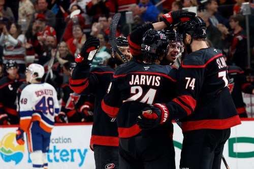 Carolina Hurricanes' Sebastian Aho, second right, celebrates his goal with teammates Jaccob Slavin, right, Seth Jarvis (24) and Jalen Chatfield, left, during the second period of an NHL hockey game against the New York Islanders in Raleigh, N.C., Saturday, April 4, 2026. (AP Photo/Karl DeBlaker)