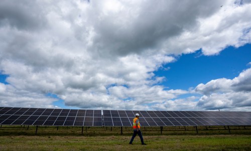 A Hydro-Québec employee walks past monofacial solar panels installed on the 5.6 hectares at the Robert-A.-Boyd Solar Power Plant in Varennes, Que., on Monday, July 21, 2025. THE CANADIAN PRESS/Christinne Muschi