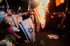 Iranian pro-government demonstrators burn the U.S. and Israeli flags during a gathering after announcement of a two-week ceasefire in the war with the United States and Israel, at the Enqelab-e-Eslami, or Islamic Revolution, Square, in Tehran, Iran, Wednesday, April 8, 2026. (AP Photo/Vahid Salemi)