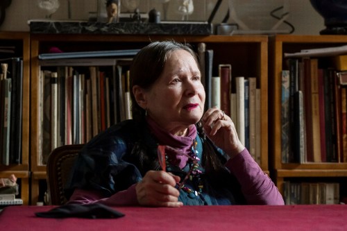 Montreal filmmaker Joyce Borenstein poses for a photograph alongside paintings by made by her father, in Montreal on Tuesday, March 3, 2026. THE CANADIAN PRESS/Christopher Katsarov