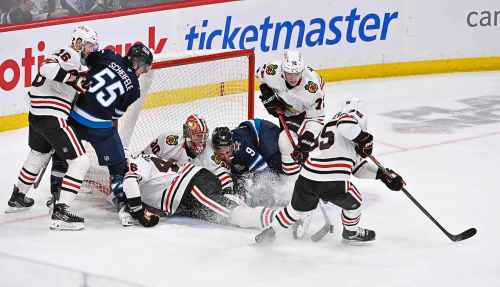 Chicago Blackhawks' Alex Vlasic (72) clears the puck to Ilya Mikheyev (95) after Winnipeg Jets' Alex Iafallo (9) collides into goaltender Spencer Knight (30) during the third period of their NHL hockey game in Winnipeg, Tuesday March 3, 2026. THE CANADIAN PRESS/Fred Greenslade