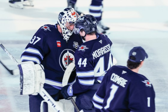 Winnipeg Jets goaltender Connor Hellebuyck (37) and Josh Morrissey (44) celebrate Morrissey's overtime goal for the win against the Vancouver Canucks on Saturday. (John Woods / The Canadian Press files)