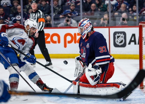 Winnipeg Jets goalie Connor Hellebuyck (37) saves the first-period shot from Colorado Avalanche's Nazem Kadri (91) on Saturday. Eric Comrie is expected to be in goal today after Hellebuyck made eight consecutive starts for the Jets. (John Woods / The Canadian Press)