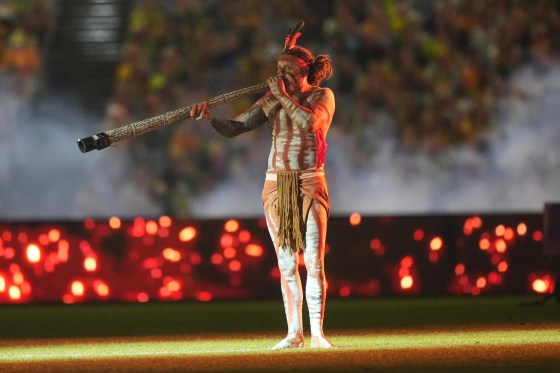 An Aboriginal man blows a didgeridoo at the start of the closing ceremony ahead of the Women's Asian Cup soccer final between Japan and Australia in Sydney on Saturday. (Mark Baker / The Associated Press)