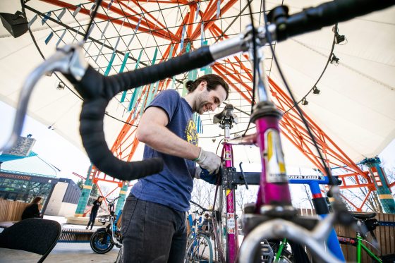 Oliver Forsyth, a mechanic with the Wrench Winnipeg, a cycling non-profit, takes a look at a bike as part of Earth Day activities today. (Mikaela MacKenzie / Free Press)