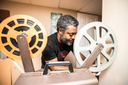 MIKAELA MACKENZIE / FREE PRESS
                                Elyas Tesfaye, a 16mm film buff who digitizes and posts his collection of films on YouTube, loads up the projector on Wednesday, April 8, 2026. For Dave Sanderson story. Free Press 2026