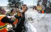 JOHN WOODS / FREE PRESS
                                People move sandbags to create a wall around a home on Peguis First Nation Sunday, Apr. 19, 2026.