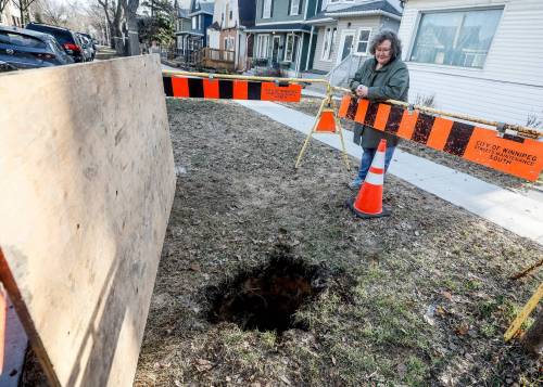 JOHN WOODS / FREE PRESS
                                Christine Keilback looks at the hole that she feel into Saturday on Lipton Street.